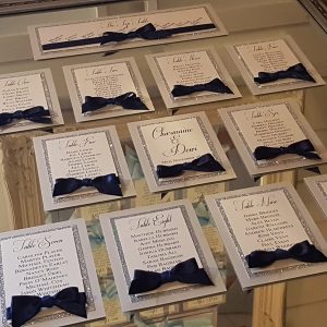 silver table plan with navy blue bows