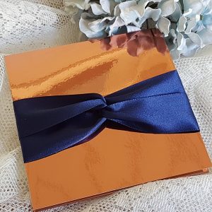 copper pocketfold invitation with navy ribbon