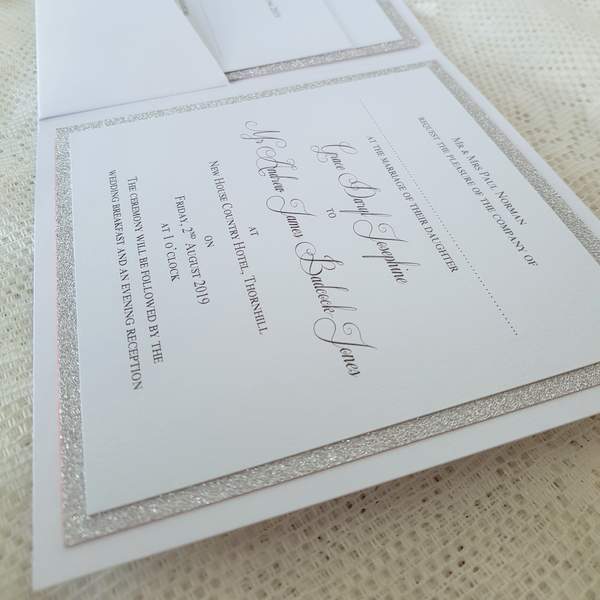 white and silver wedding invitation showing details