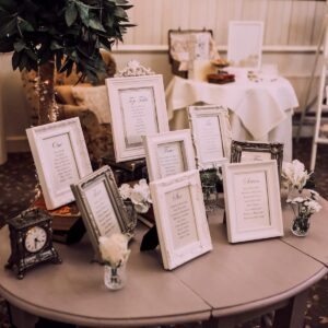a wedding table plan made with picture frames on a table at different heights