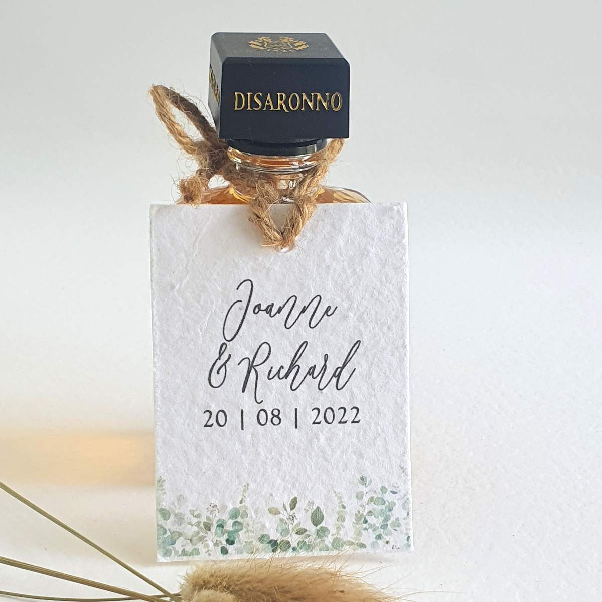 a miniature alcohol bottle wedding favour with a tag made from plantable seed paper