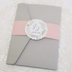 pink and grey pocketfold wedding invitation with greenery
