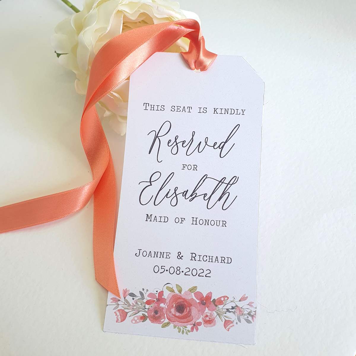 wedding reserved seating tag with coral floral print and ribbon