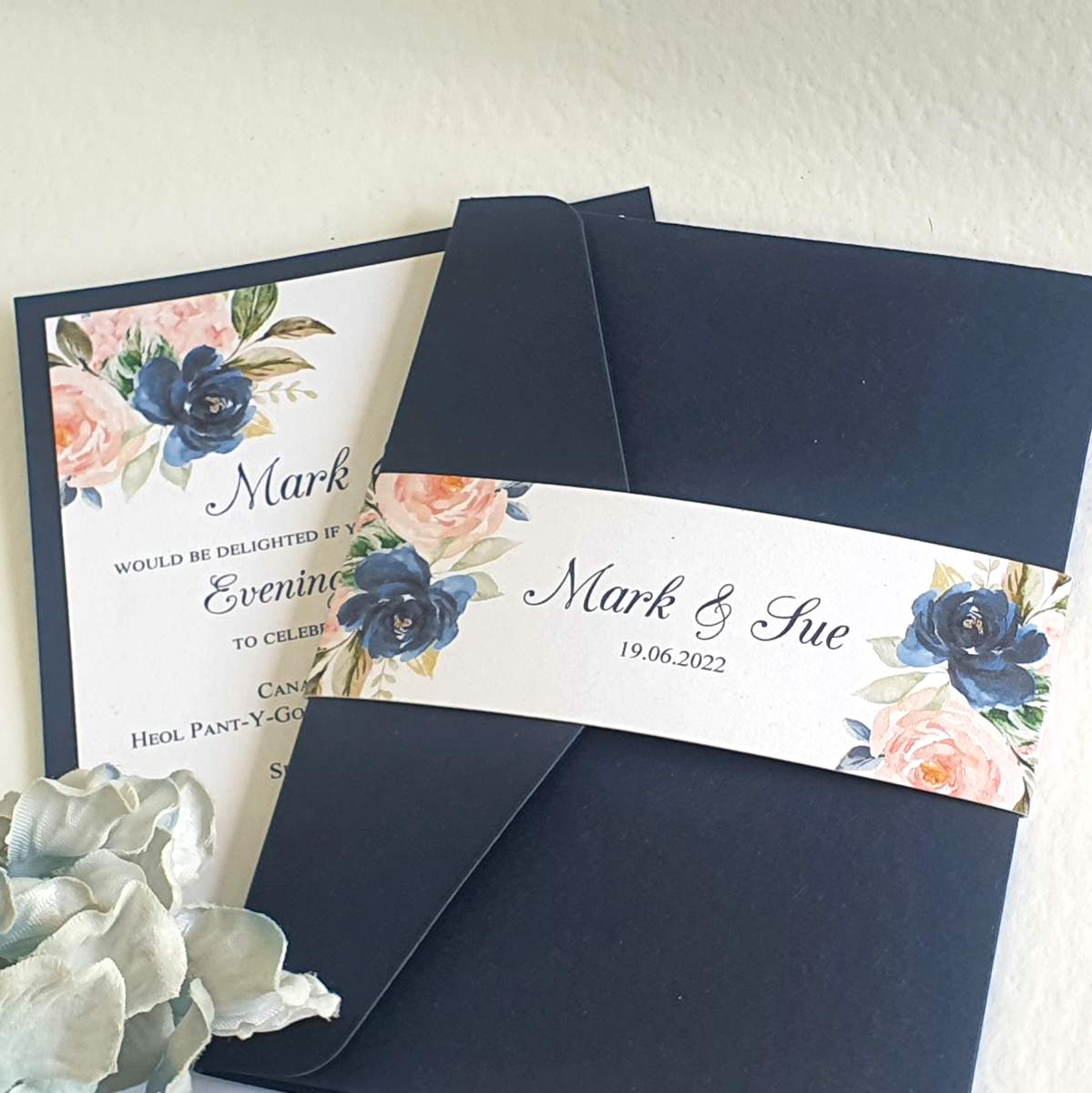 a set of wedding invitations in a navy and blush colour scheme with a pretty floral design