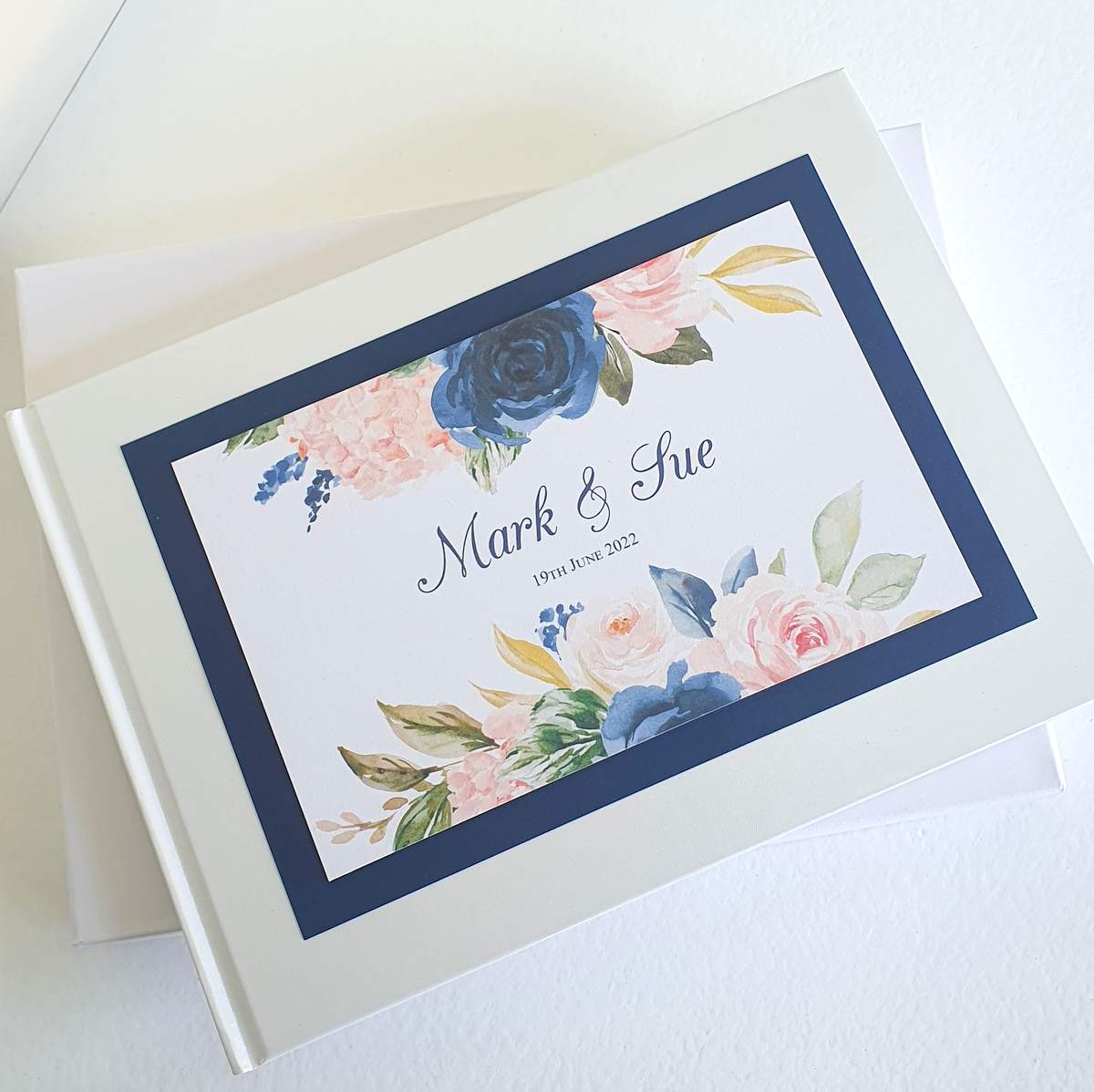 wedding guest book personalised with the bride and grooms names and a navy and blush floral design