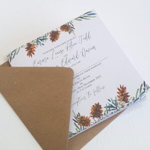 a wedding invitation with fir tree and pine cone design