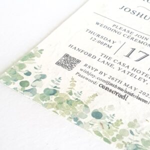 a seed paper wedding invitation with a greenery foliage design at the bottom, it shows wording and a QR code for replies