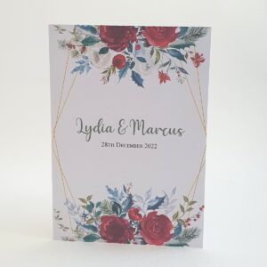 the front cover of a christmas wedding invitation with green foliage and red flowers