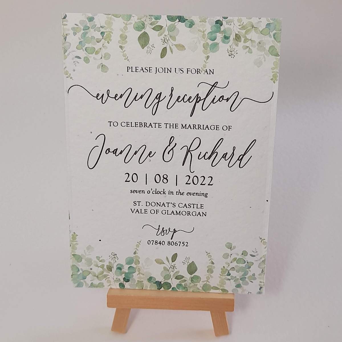 a wedding invitation with leafy greenery design to the top and bottom, printed onto plantable seed paper