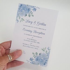 a wedding evening invitation with a sky blue floral design in the corners