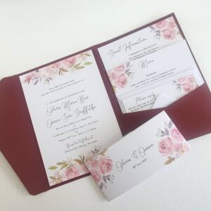 a wedding invitation with a burgundy card pocket and inserts printed with a mauve floral design