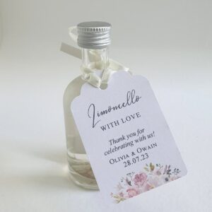 a personalised wedding favour tag tied around a small bottle, the tag says limoncello with love