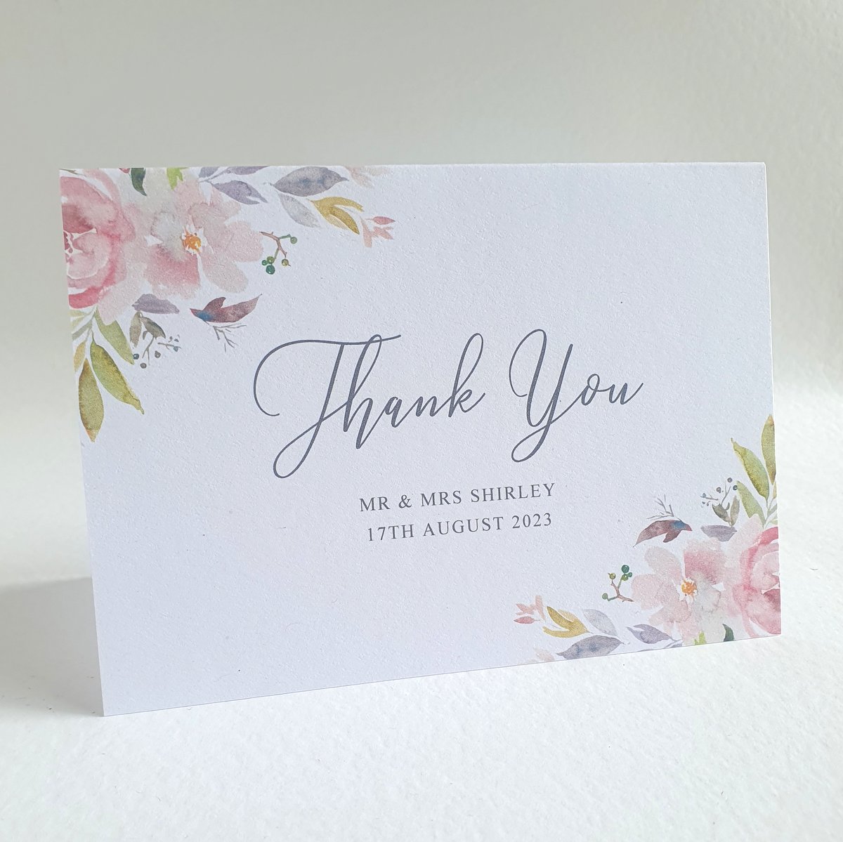 a personalised wedding thank you card with mauve floral accents to the corners