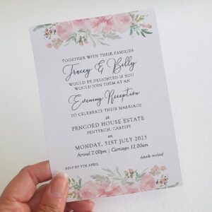 an evening wedding invitation with blush pink flowers at the top and bottom