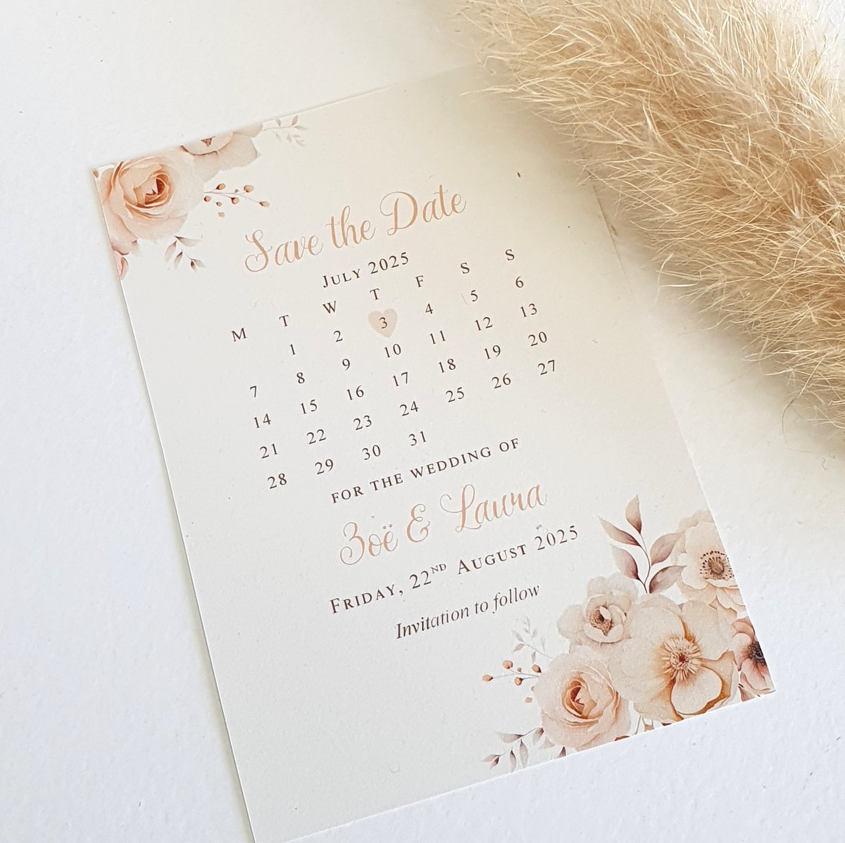 a wedding save the date card with a calendar showing the wedding date. Champagne floral design to the corners