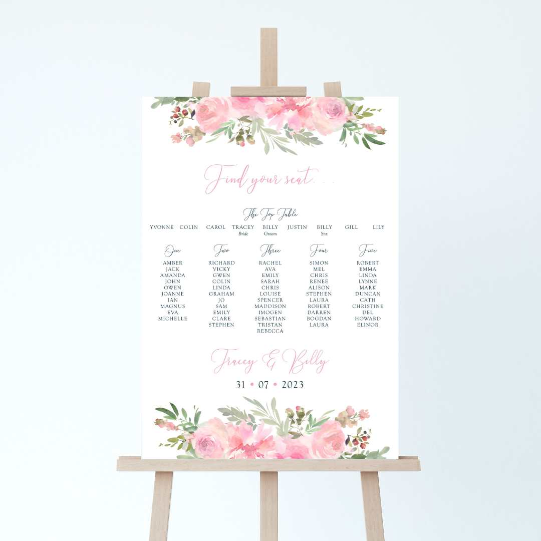a wedding table plan board on an easel, it has a pink floral design to the top and the bottom