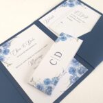 navy blue pocketfold wedding invitation with inserts printed with a floral design